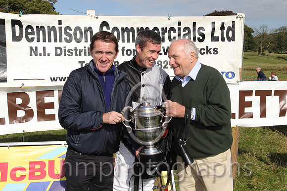 Tony McCoy presents the winners cup to jockey Derek O'Connor and owner and sponsor of the race Wilson Dennison at the Mid-Antrim Hunt Point to Point at Toomebridge