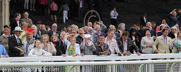 Spectators watch the Irish Parachute Club members descend to the track at the irish Derby at the Curragh
