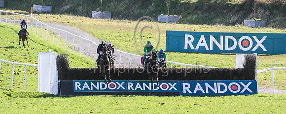 Malina Girl (4, green) ridden by Keith Donoghue jump the peniltimate fence to go to win the Randox Ulster National Handicap Steeplechase at DOnwpatrick on 2nd April 2023. Maina Girl is trained by Gavi