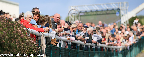 Spectators crowd the railings awaiting the horses at Downpatrick Races on 12th June 2022