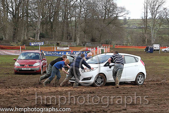 Car being pushed out of mud at the East Antrim Hunt Point to Point at Loughanmore om Easter Tuesday
