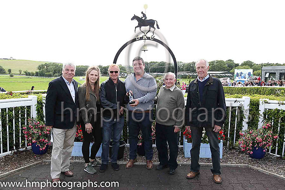 Brian Reid Formula 2 Motor Cycle World Champion in 1985 and 1986 presenting the prize to winning trainer Thomas Hughes after his horse won the Mares Handicap Hurdle at Downpatrick. Also in picture ext