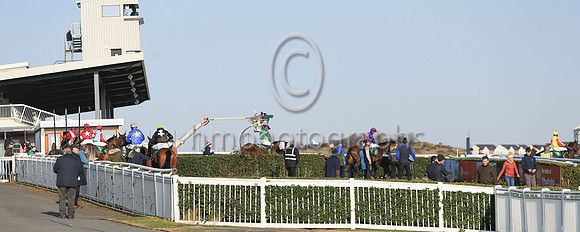 Horses and jockeys leave the parade ring at the Randox Ulster National Meeting at Downpatrick Racecourse where the public were banned because of the COVID-19 restrictions