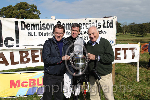 Tony McCoy presents the winners cup to jockey Derek O'Connor and owner and sponsor of the race Wilson Dennison at the Mid-Antrim Hunt Point to Point at Toomebridge