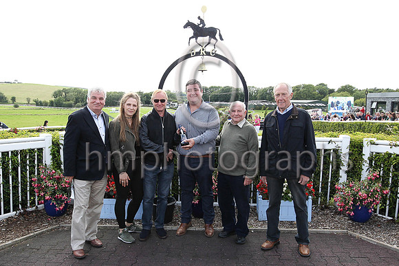 Brian Reid Formula 2 Motor Cycle World Champion in 1985 and 1986 presenting the prize to winning trainer Thomas Hughes after his horse won the Mares Handicap Hurdle at Downpatrick. Also in picture ex