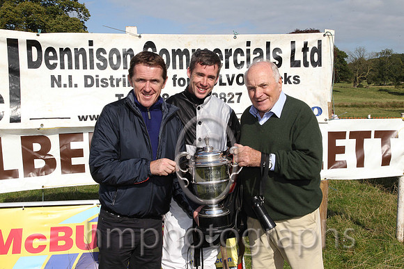 Tony McCoy presents the winners cup to jockey Derek O'Connor and owner and sponsor of the race Wilson Dennison at the Mid-Antrim Hunt Point to Point at Toomebridge