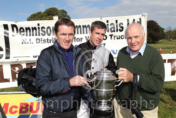 Tony McCoy presents the winners cup to jockey Derek O'Connor and owner and sponsor of the race Wilson Dennison at the Mid-Antrim Hunt Point to Point at Toomebridge